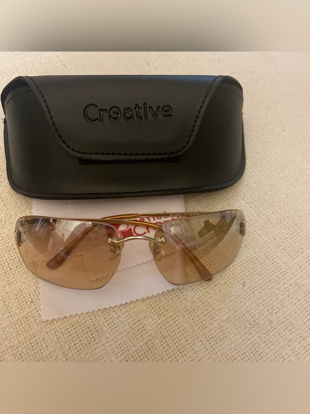 2000s style creative optics sunglasses with brown lenses and gold frames